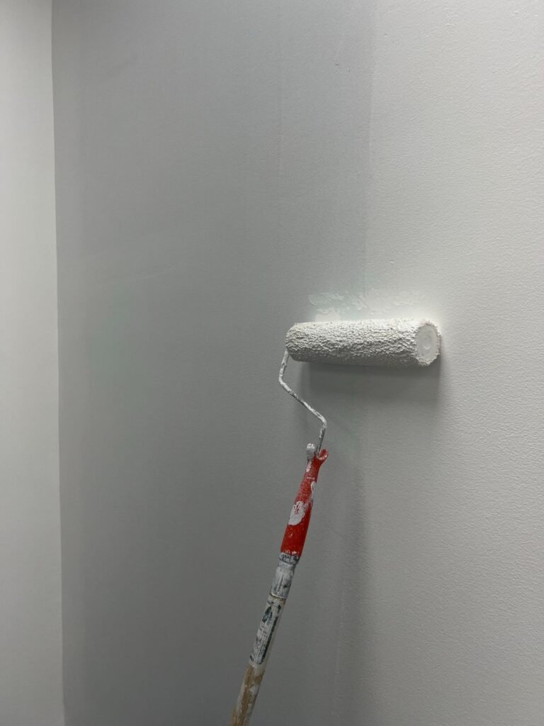 Paint roller applying a fresh coat to an interior wall